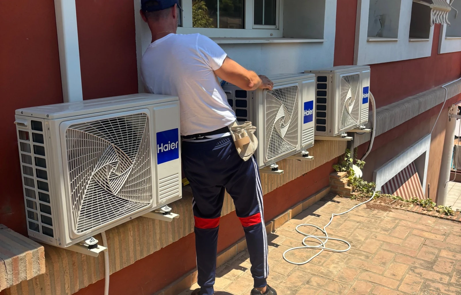 Técnico de NAVTERIS trabajando en una instalación con varias unidades exteriores Haier